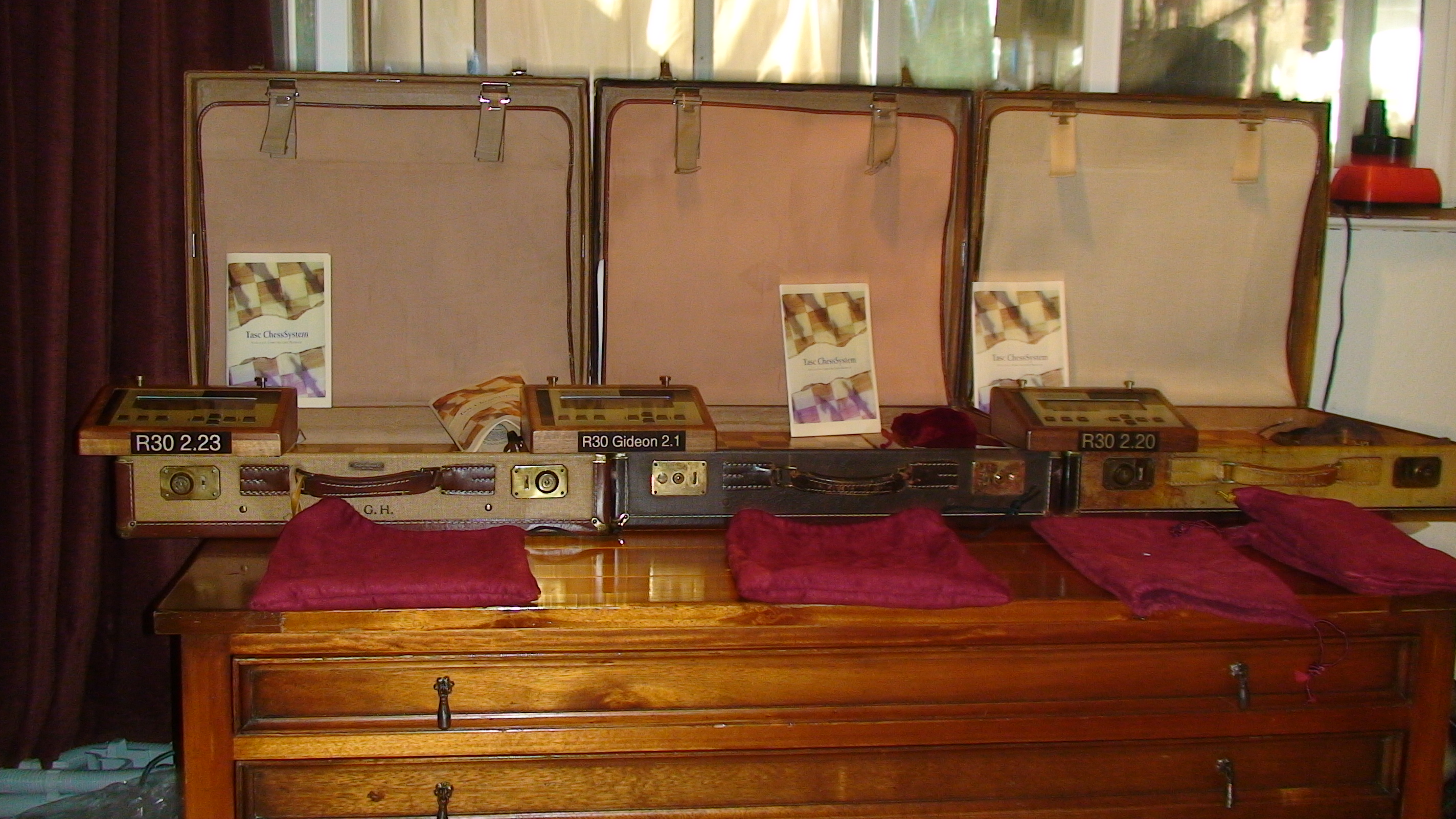 Comparison view of three TASC control units and their carrying cases.